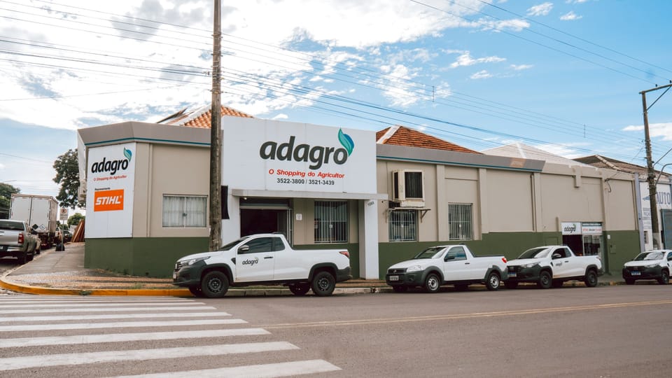 Fachada de uma loja da Adagro, com a marca STIHL e carros estacionados em frente